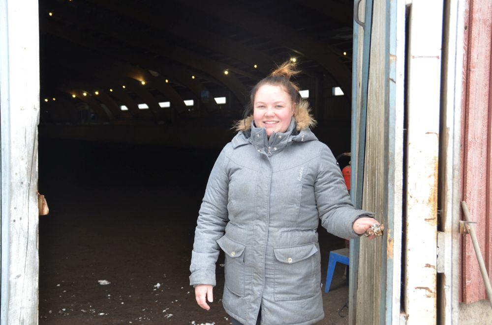 Ung kvinna håller upp dörren till en manege.