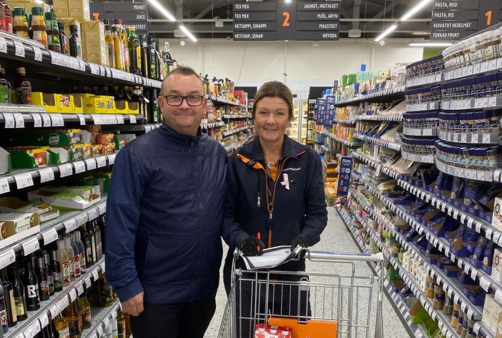 Man och kvinna mellan butikshyllor