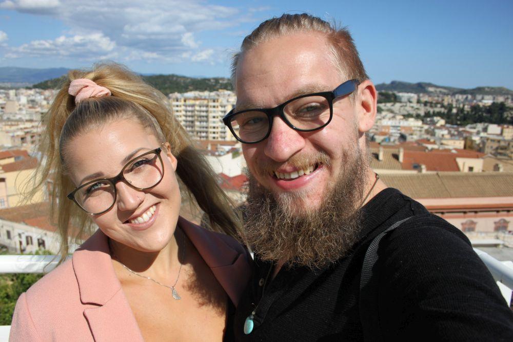 En kvinna och en man med en stad i bakgrunden.