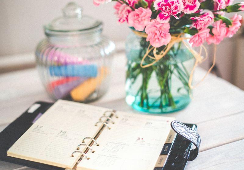 Kalender på bord med blomvas