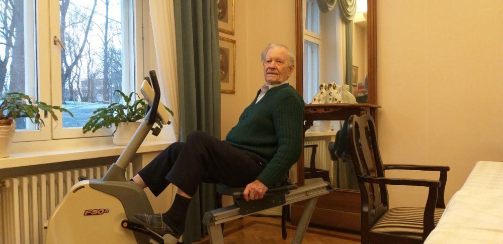 Äldre vit man sitter på en motionscykel