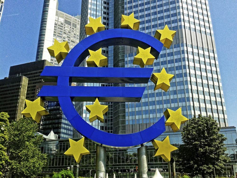 Eurosymbol på en bild med höga hus.