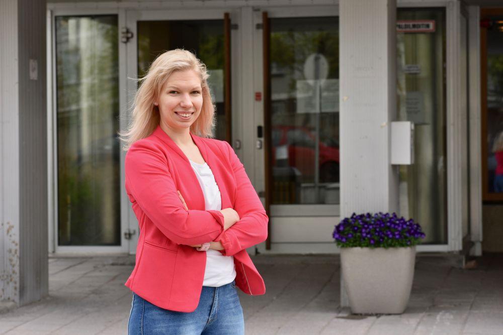 Porträtt av en kvinna som står framför en ingång till ett universitet.