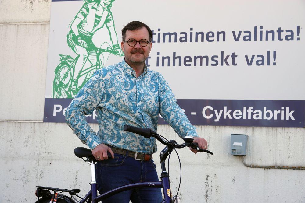 man står och håller i cykel.
