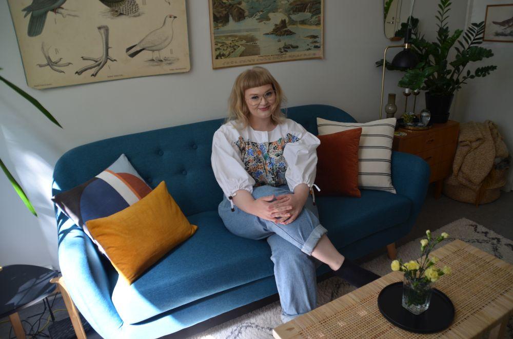 En kvinna sitter på en soffa.
