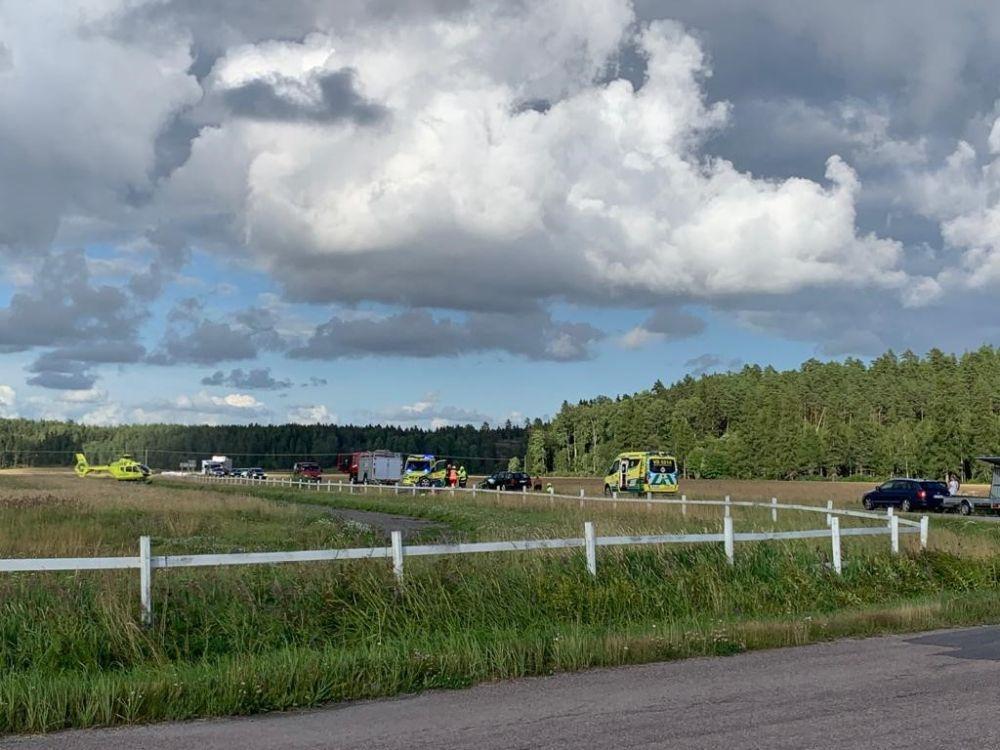 Åker och i bakgrunden räddningsfordon och en helikopter.