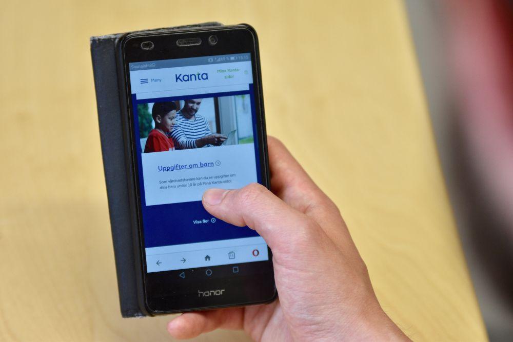 En hand som håller i en mobiltelefon.