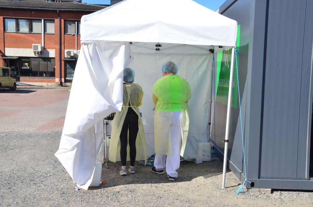 Laboratorieskötare i ett testbås utomhus.