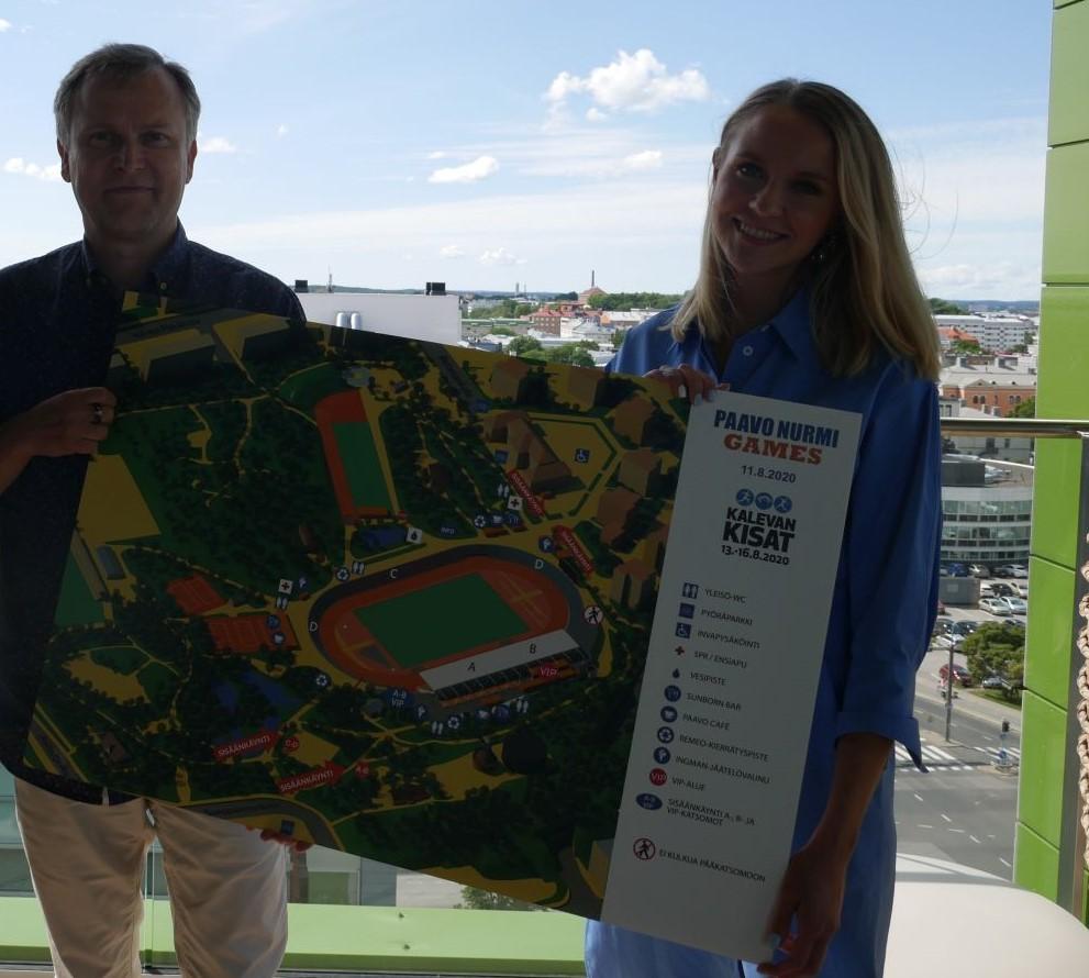 En man och en kvinna håller i en karta över en idrotsstadion tillsammans.