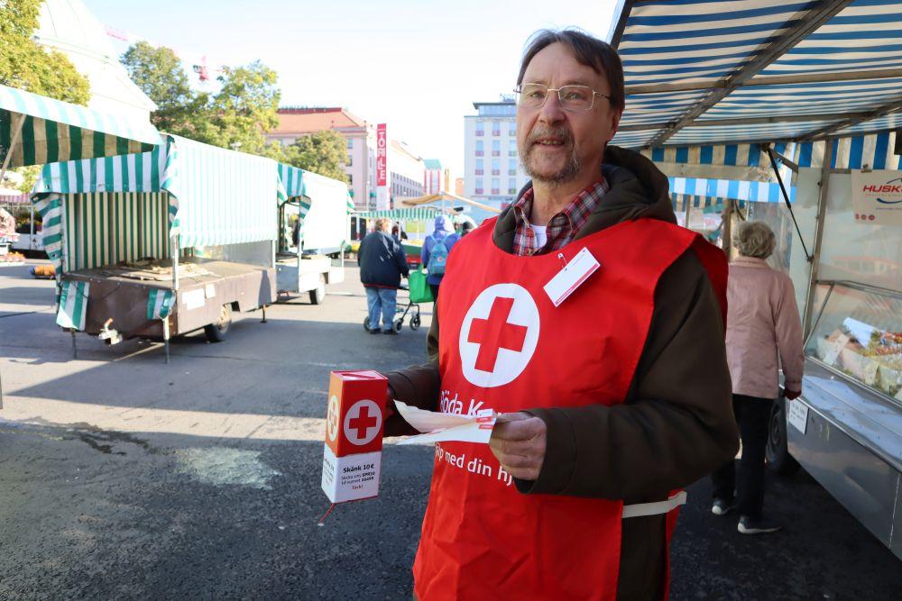man står med röda kors-väst och insamlingsbössa för hungerdagen